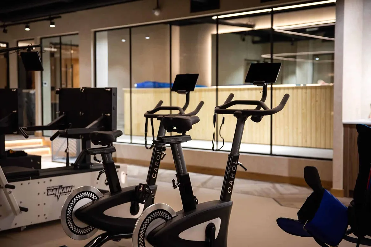 Two CAROL exercise bikes with digital displays set up in a modern gym studio