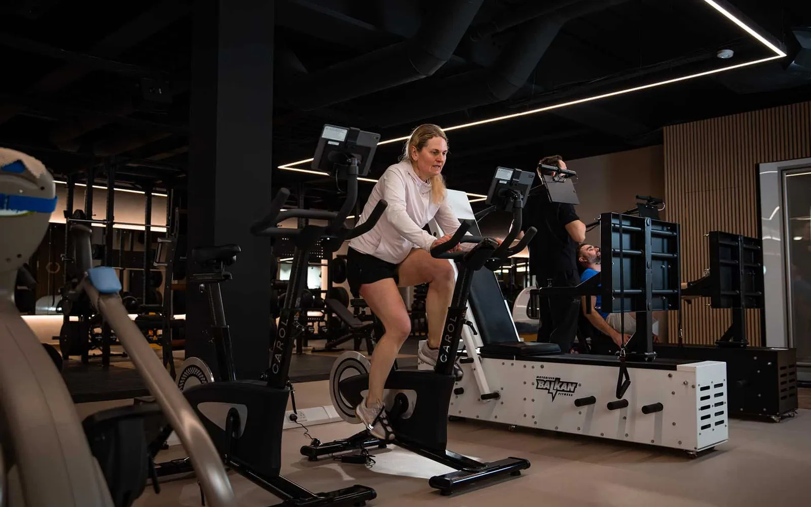 A member rides the CAROL bike for a REHIIT session in the gym at The FIT Partnership in Esher