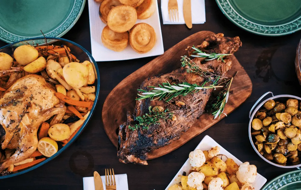 A Christmas dinner spread with roast meat, Yorkshire puddings, roasted vegetables and sprouts