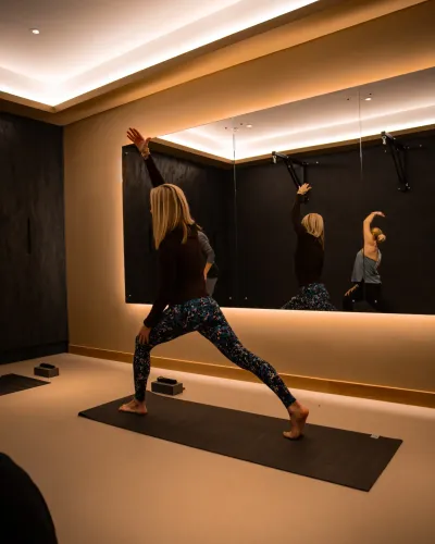 A member stretches into a lunge pose in the mirrored studio at The FIT Partnership